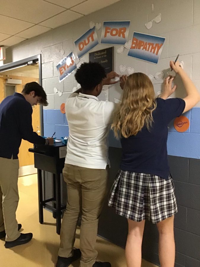 Students adding to the Eyes Out for Empathy wall