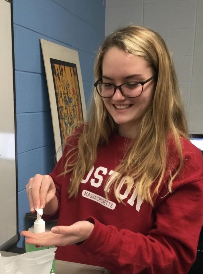 Fiona Roach cleans her hands, showing how classrooms have been restocked with hand sanitizer and bacterial wipes.