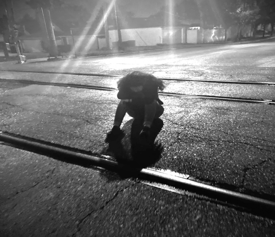 Female+student+sits+on+railroad+tracks