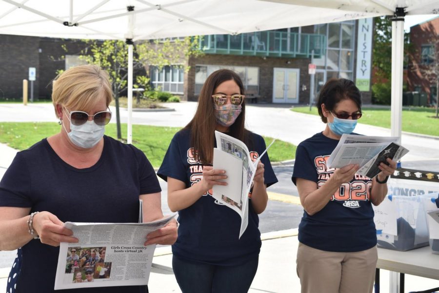 Naz Principal Therese Hawkins, Director of Curriculum and Instruction Jessica Radogno and Director of Finance Mary Callaghan read The Announcer 2020 print edition