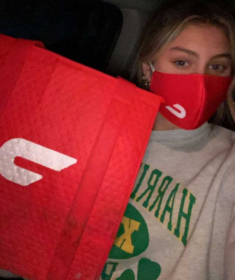Isa Byzcek takes a selfie with her DoorDash mask and bag as she is ready to deliver food. 