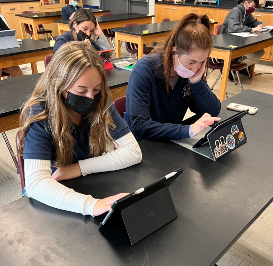 Seniors Mia Marano and Mia Gurka doing work on their iPads. 