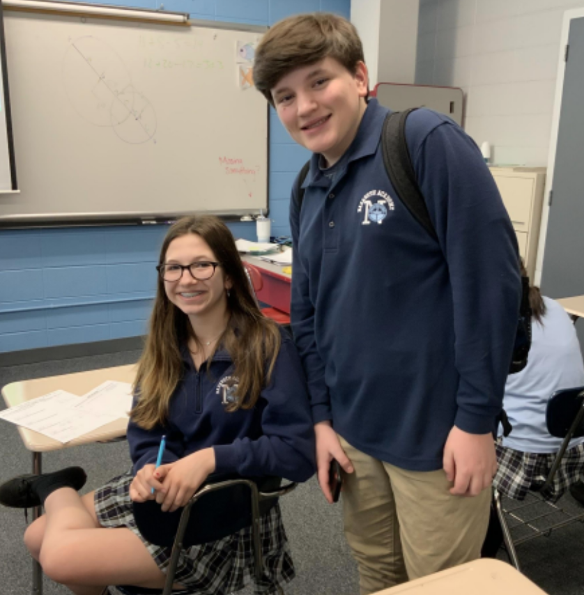 Sophomores Juliana Caruso and Charlie Arenz discussing the current uniforms policy in Geometry class.	